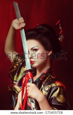 Beautiful geisha in kimono with samurai sword