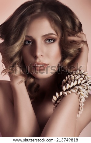 Portrait of beautiful young woman with makeup and shell necklace.