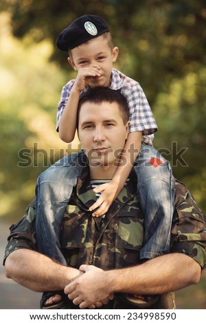 Little boy and soldier in a military uniform say goodbye before a separation