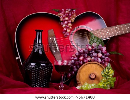 Beautiful composition with wine, grape and guitar on red background