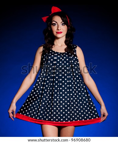 Vintage woman in retro dress on dark background. Pin-up girl
