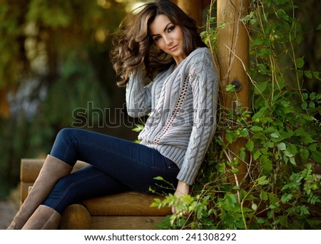 Portrait of beautiful young woman with makeup in fashion clothes on hature