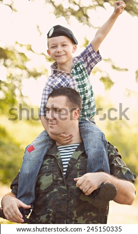 boy and soldier in a military uniform say goodbye before a separation
