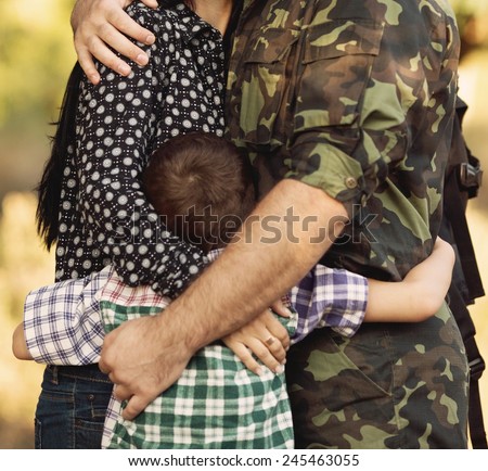 Family and soldier in a military uniform say goodbye before a separation