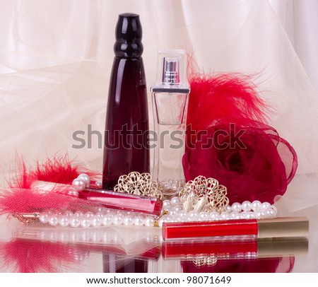 Perfume bottles, red lipstick, feather, rose and pearls beads