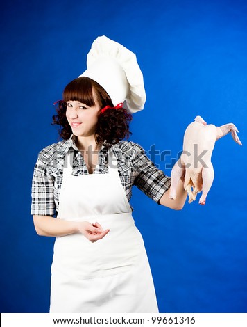 Smiling happy cook woman holds a Crude hen
