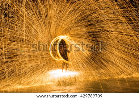 Burning steel wool spinned in urban area. Showers of glowing sparks from spinning steel wool