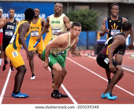 Eugene, Oregon June 12, 2014 - Devon Allan (C) of the University of Oregon prepares to take the baton from teammate Arthur Delaney in the 4X100m relay at the 2014 NCAA Track & Field Championships