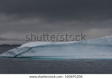 Ominous iceberg with penguins near Useful Island, Antarctica