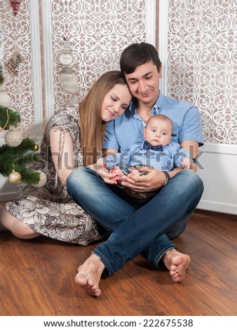 Beautiful family with a baby near Christmas tree. Family Portrait