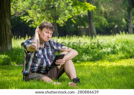 Student studying in the park sitting on the grass