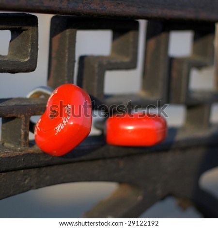 Red metal heart locks on the bridge railing