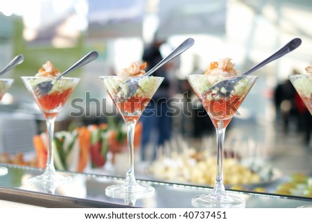 Three shrimp cocktails in a martini glass with fork inside.