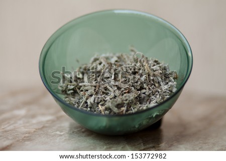 Sage herb tea in bowl and on table