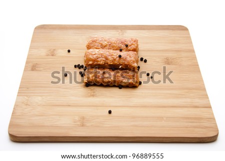 Cevapcici with peppercorn on wood plate