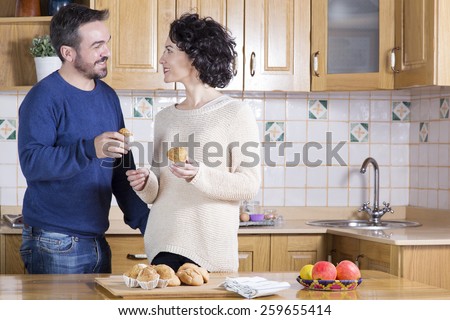 Man and woman eating delicious homemade cupcakes. Happy couple looking at each other while taking delicious cakes