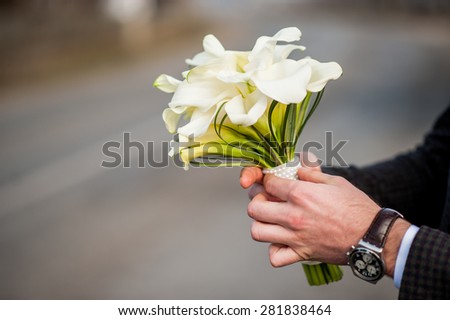 Fresh tulip bouquet in hands of the groom
