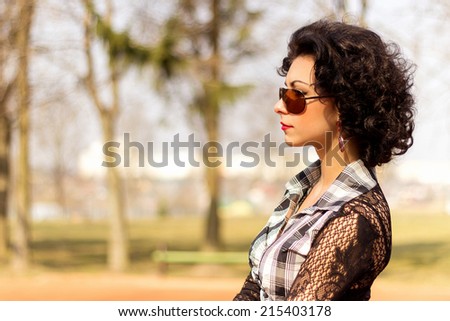 portrait of a beautiful sexy girl with red lips brunette with curls walks in the Park