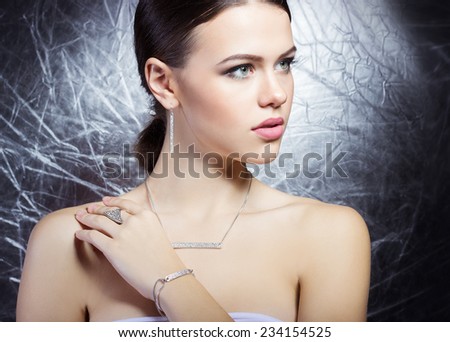 beautiful young girl with beautiful stylish expensive jewelry, necklace, earrings, bracelet, ring, filming in the Studio