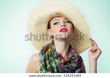 beautiful young girl with a hat bright makeup with color beautiful expensive scarf at the neck on white background in Studio