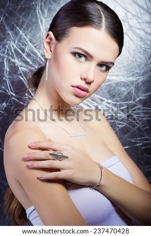 beautiful young girl with beautiful stylish expensive jewelry, necklace, earrings, bracelet, ring, filming in the Studio