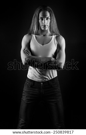 guy male model with long hair posing in Studio on black background and a white t-shirt and jeans