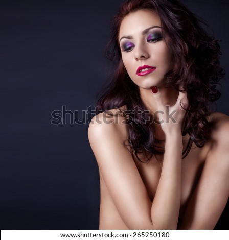beautiful sexy Nude woman covered with hands body with beautiful bright makeup, wavy black hair with red lipstick in a Studio fashion shoot