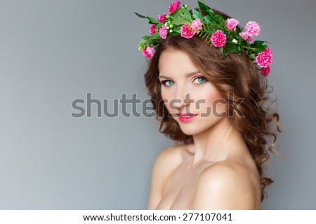 sweet sweet beautiful sexy young girl with a wreath of flowers on her head, with bare shoulders with beauty makeup soft pink lips , a cute look at the camera