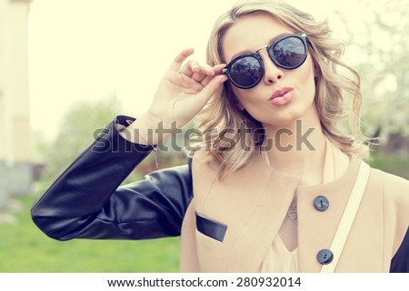 Beautiful young sexy girl in sunglasses walking on a bright sunny summer day on city streets