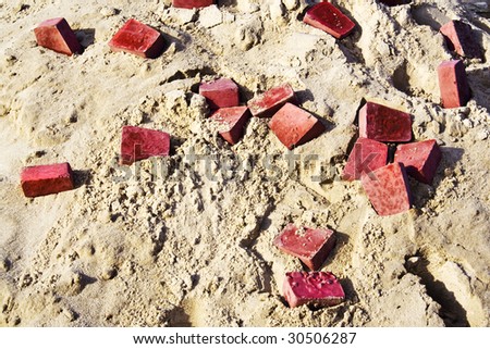 Heap of red brick and building sand. Hot beige dirty sand texture