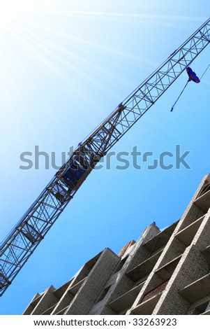 Building crane and building house against the blue sky. Building site