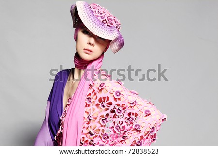 Beautiful caucasian woman in pink elegant dress on grey background. Studio shot