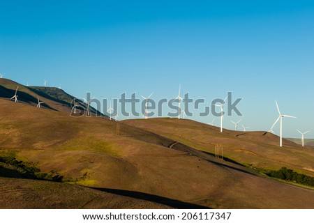 Wind power stations producing clean energy in a dry desert during a bright summer day