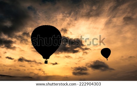 Hot air balloons taking off in a sunrise with beautiful clouds in the background. A relaxing ballooning flying experience for vacation.
