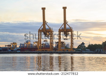 Working crane loading bridge in shipyard at sunrise time for Logistic Import Export background