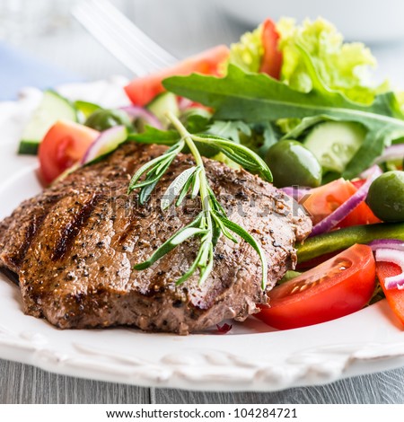 Grilled beef steak with salad and rosemary sprig