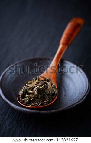 Green tea leaves on a bamboo spoon