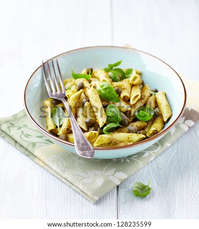Penne with basil pesto and fresh basil leaves