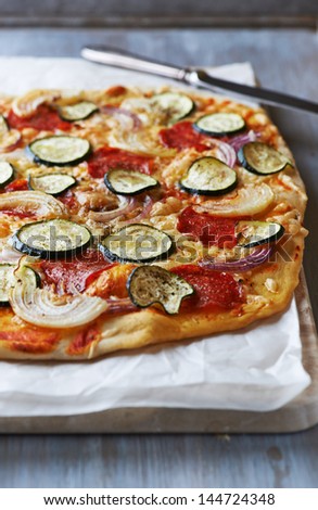 Pizza with zucchini, onion and salami