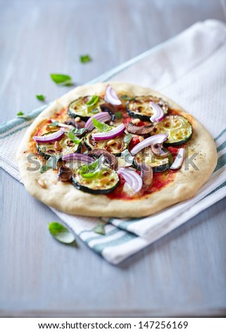 Pizza with grilled zucchini, mushrooms and pine nuts