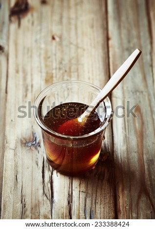 Buckwheat honey in a glass with wooden spoon