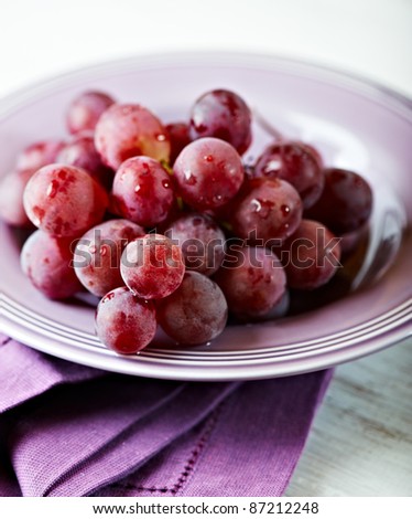 Fresh red grapes in a purple bowl