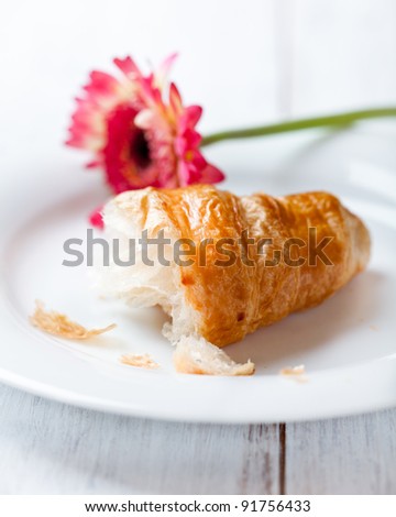 Croissant with pink flower on a plate