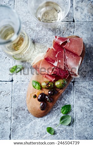 Dry cured ham, marinated olives and white wine (seen from above)
