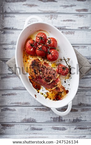Chicken breast wrapped in bacon, baked with cherry tomatoes