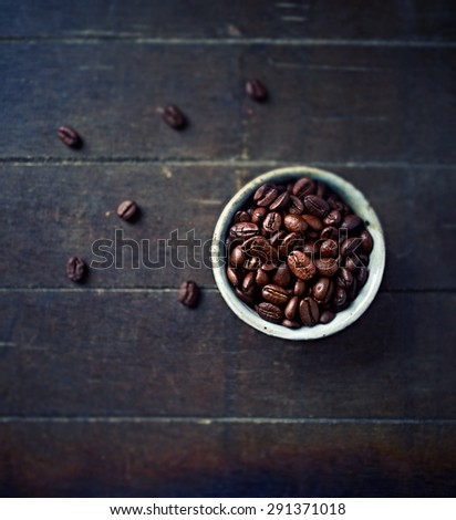 Dark roasted coffee beans in a ceramic cup