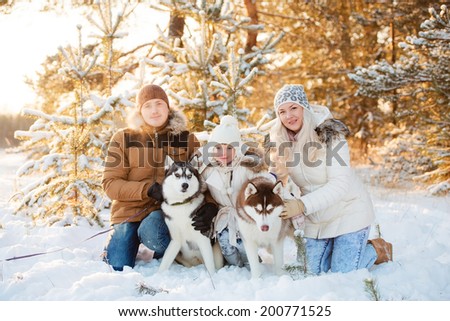 Laughing family and husky dog in winter park