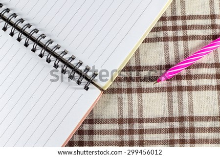 Open blank notebook and pen on the floor