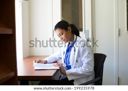 Closeup portrait, woman healthcare professional with stethoscope enjoying reading, studying in library room
