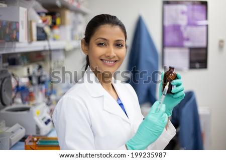 Closeup portrait, smart woman scientist in white labcoat holding syringe needle and brown bottle in isolated lab background